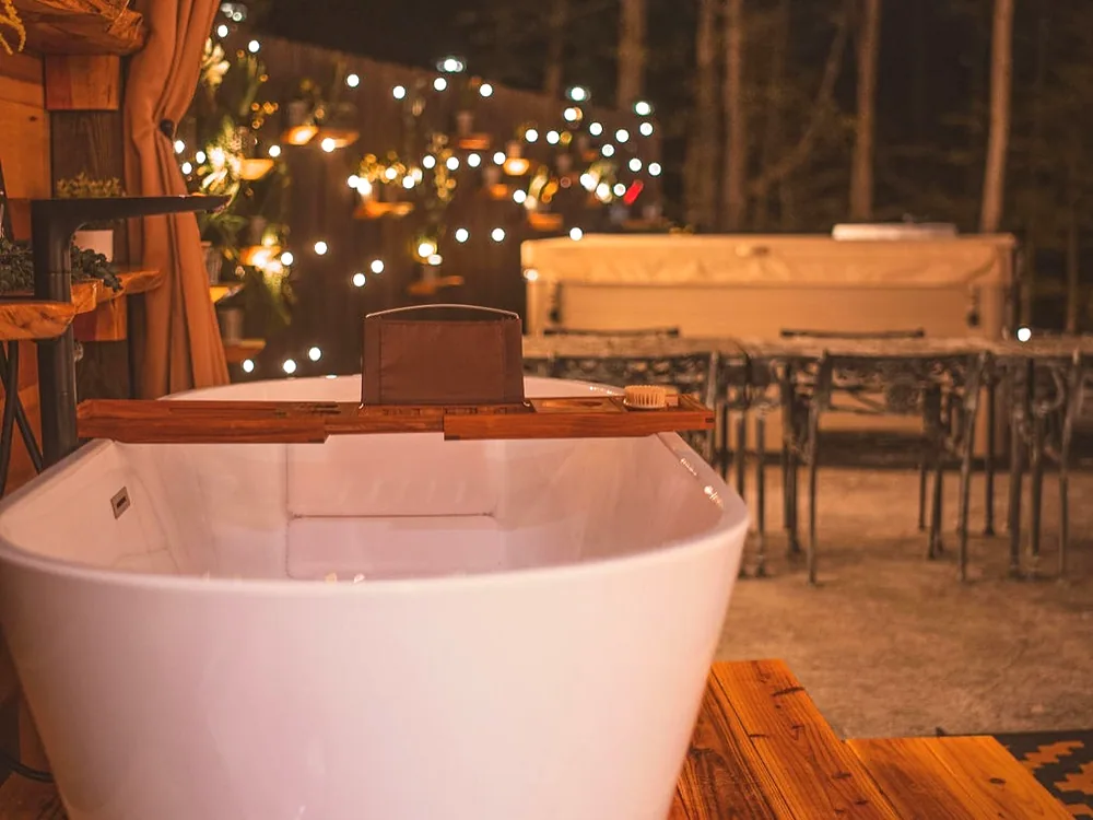 The soaking tub, lights in the window behind it