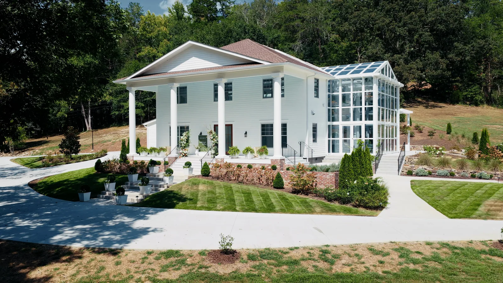 The Magnolia House from the lawn: white columns at the front, the glass conservatory behind
