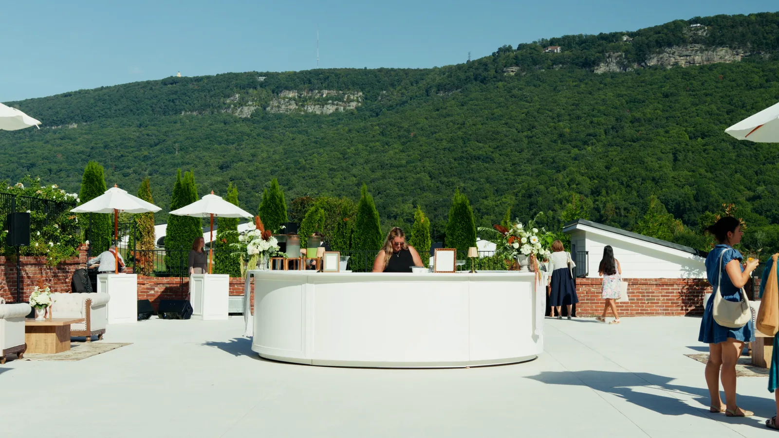 The terrace at the opening: a round bar, umbrellas and the ridge beyond